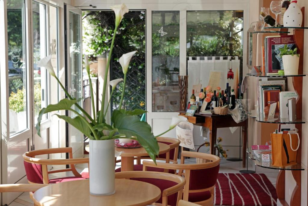 un vase avec des fleurs sur une table dans une pièce dans l'établissement Hotel b&b Villa Irma, à Rimini