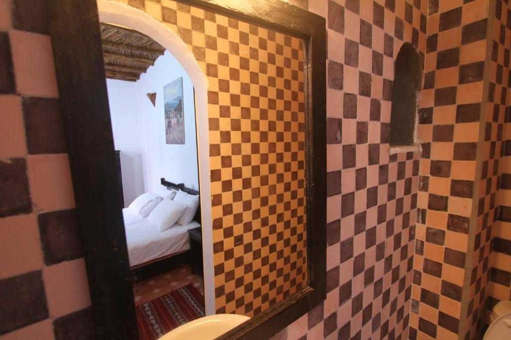 - un miroir dans la salle de bains avec un lit dans la chambre dans l'établissement Dar Tranquille, à Essaouira