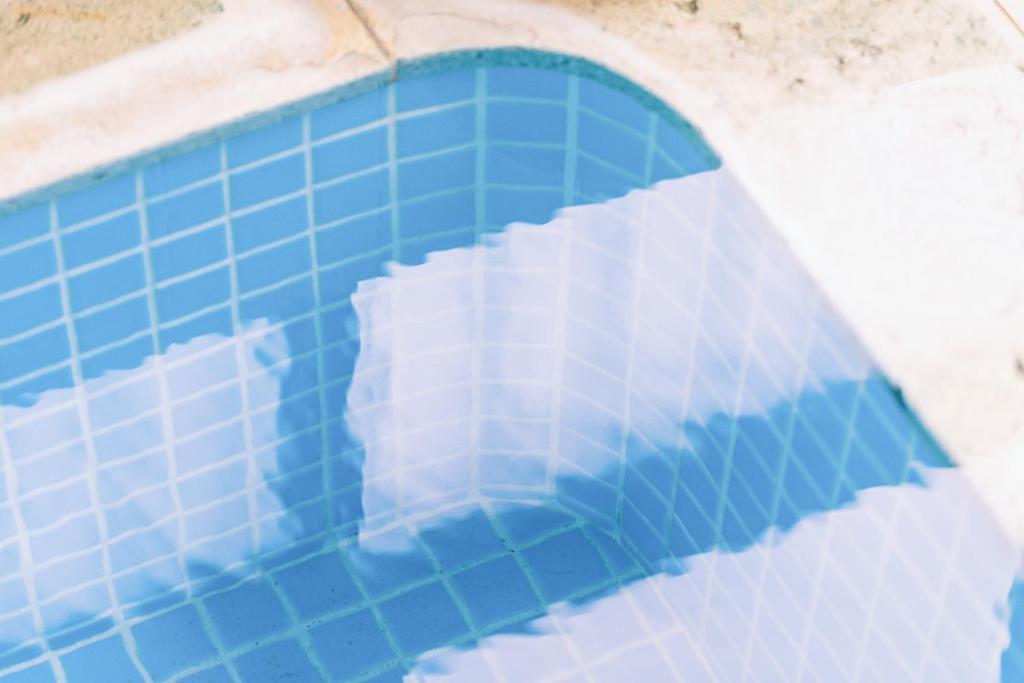 une piscine avec une réflexion sur le ciel dans l'eau dans l'établissement Ogawa Ryokan, à Shimoda