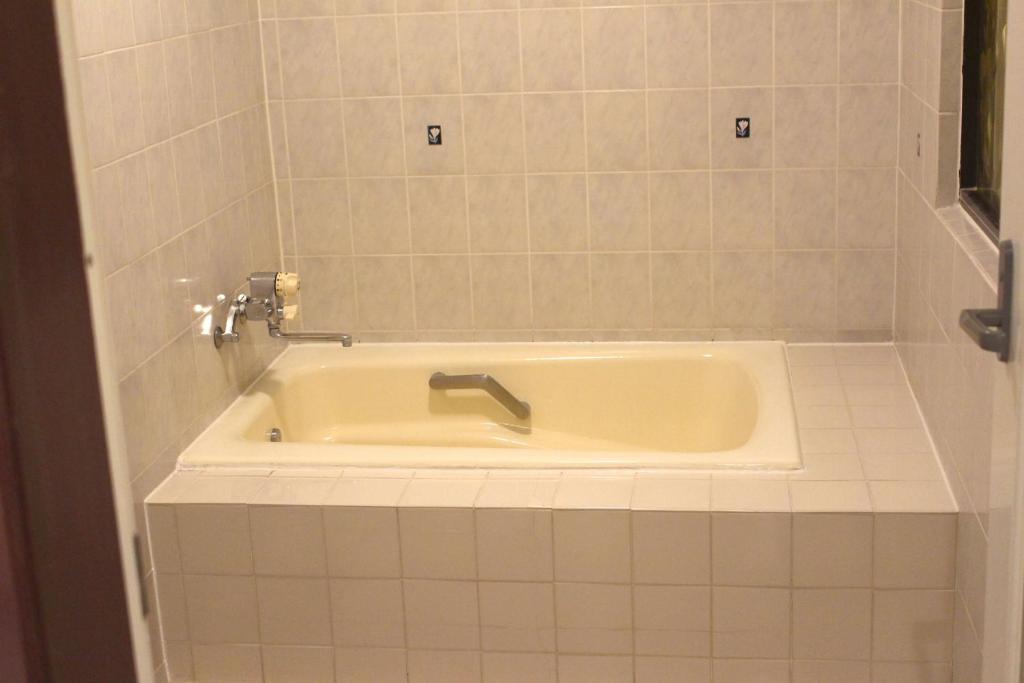 une baignoire avec un robinet dans une salle de bain dans l'établissement Pal Annex Munakata (Love Hotel), à Munakata