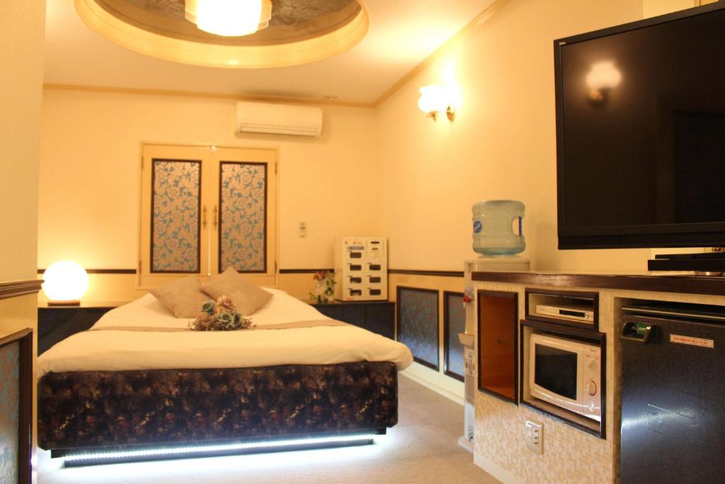une chambre avec un lit et une télévision à écran plat dans l'établissement Pal Annex Munakata (Love Hotel), à Munakata