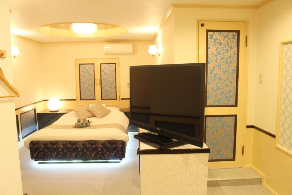une chambre avec un lit et une télévision à écran plat dans l'établissement Pal Annex Munakata (Love Hotel), à Munakata