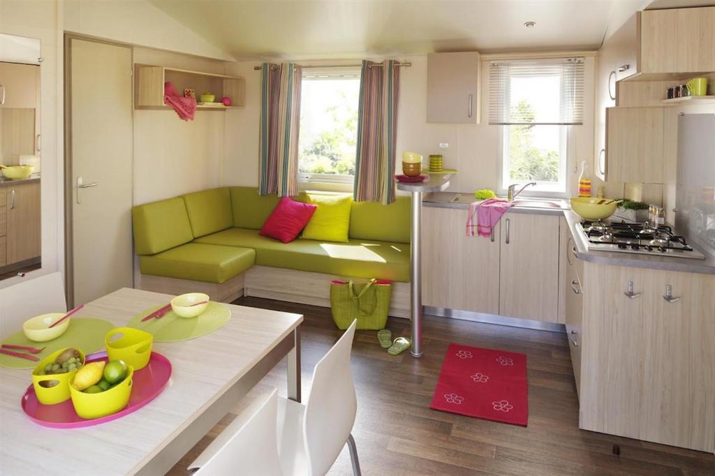 un salon avec un canapé vert et une cuisine dans l'établissement Bungalow Vacances, à Biot 37 autres photos
