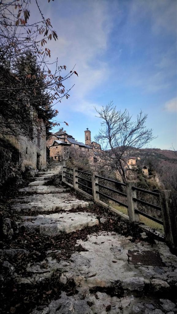 un chemin en pierre avec une clôture et un bâtiment dans l'établissement Sur Un Petit Nuage, à Roubion