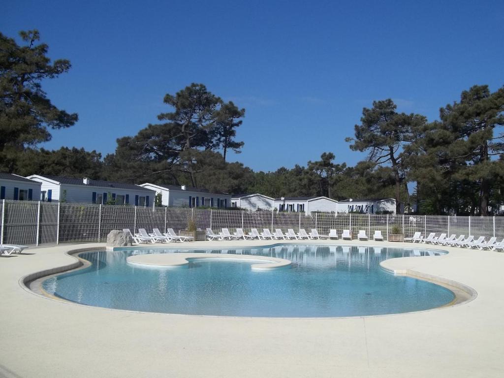 - une piscine avec des chaises blanches et de l'eau dans l'établissement Camping Paradis Les Galets de la Molliere, à Cayeux-sur-Mer 37 autres photos