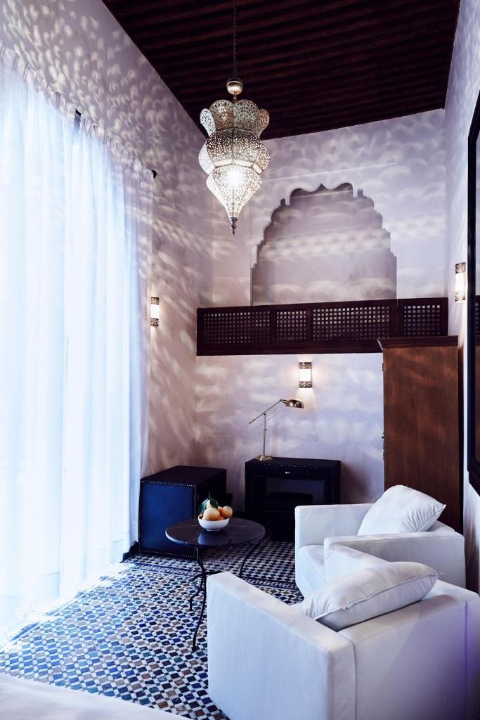 d'un salon avec un canapé blanc et un lustre. dans l'établissement Chaq Chaq, à Fès