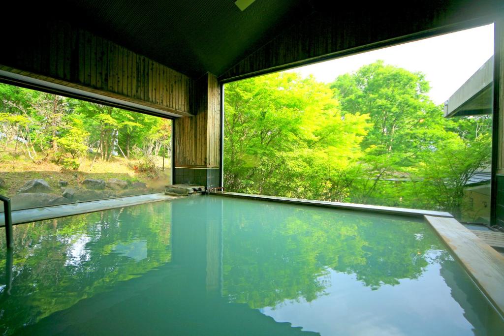 - une piscine dans une maison avec une grande fenêtre dans l'établissement Hotel Shikisai, à Nikkō