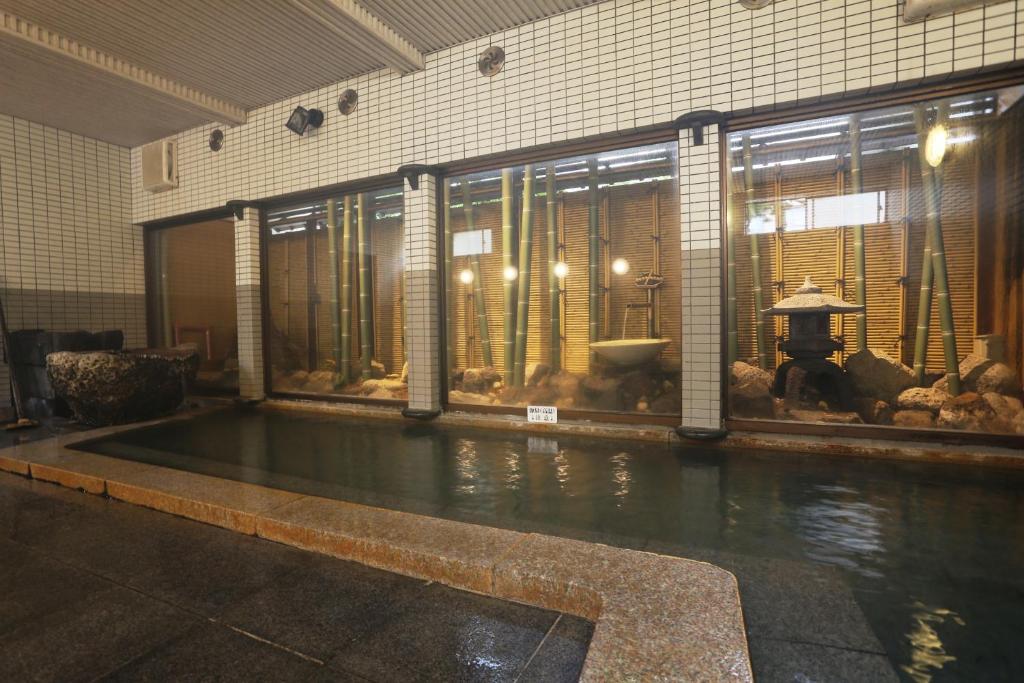 une grande piscine d'eau dans un bâtiment dans l'établissement Kaichoen, à Yonago