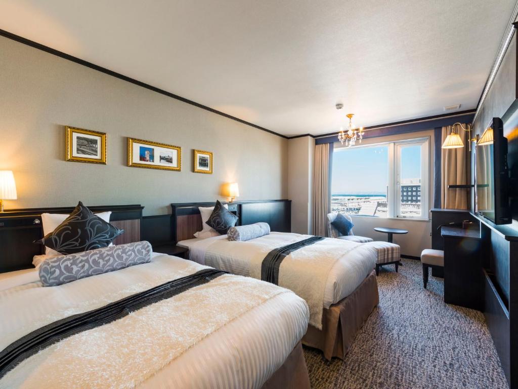 une chambre d'hôtel avec deux lits et une fenêtre dans l'établissement Hotel Sonia Otaru, à Otaru 72 autres photos