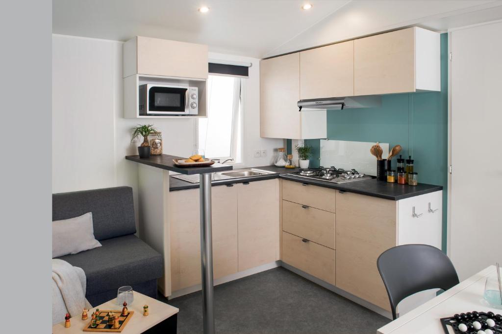 une petite cuisine avec un canapé et une table dans l'établissement Camping du canal, à Kembs 34 autres photos