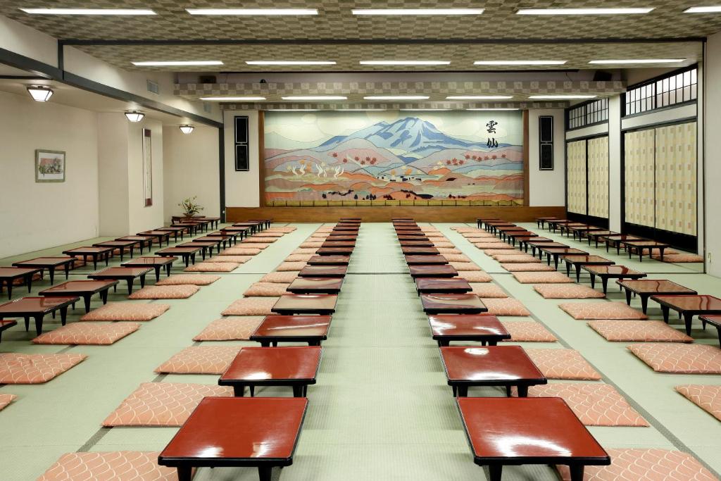 une rangée de bancs dans une pièce avec une fresque murale dans l'établissement Unzen Sky Hotel, à Unzen 37 autres photos
