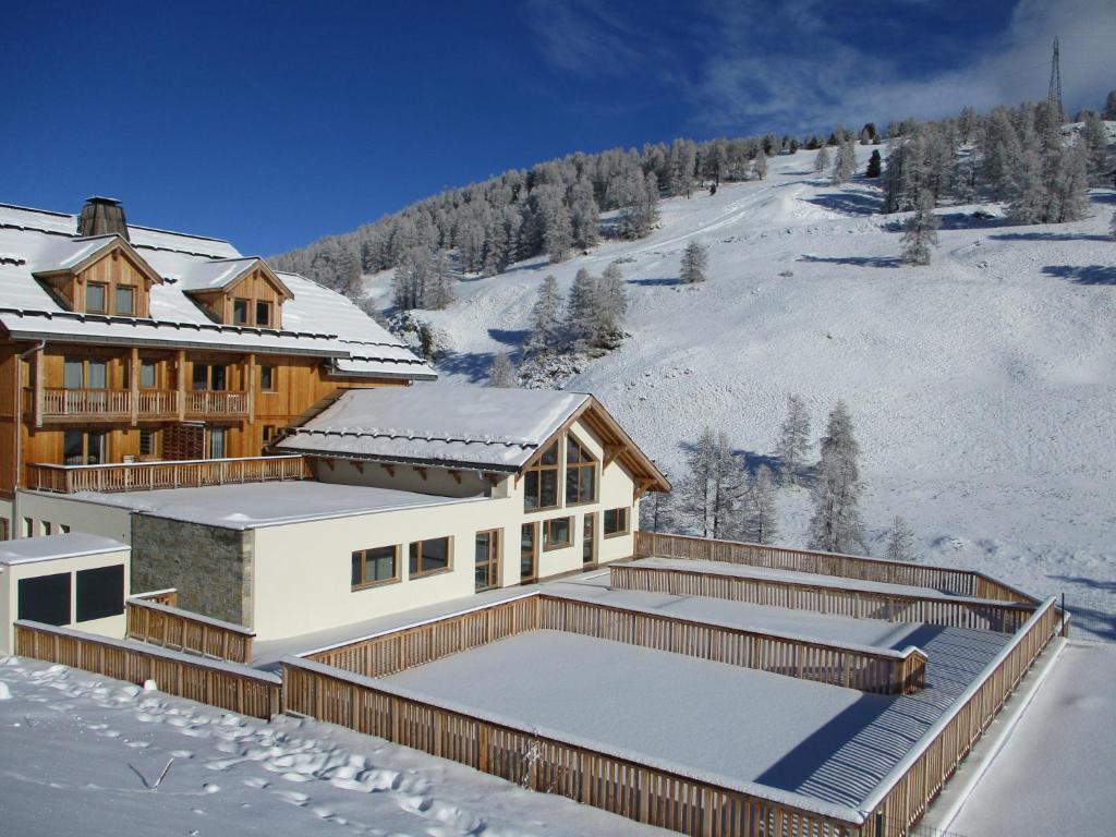 une maison dans la neige avec une terrasse dans l'établissement Duplex Familial à Vars, Chalets des Rennes, à Vars