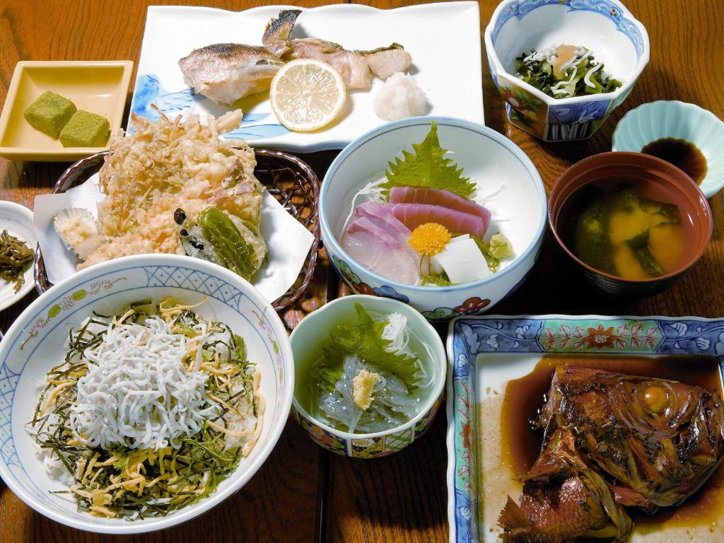 une table recouverte de bols de différents types de denrées alimentaires dans l'établissement Kakiya Ryokan, à Kamakura