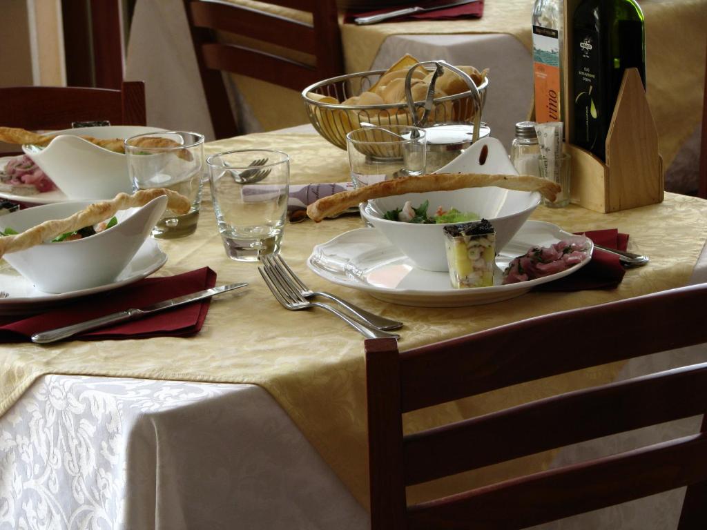 une table avec des assiettes de nourriture et des verres dessus dans l'établissement Hotel b&b Villa Irma, à Rimini 20 autres photos