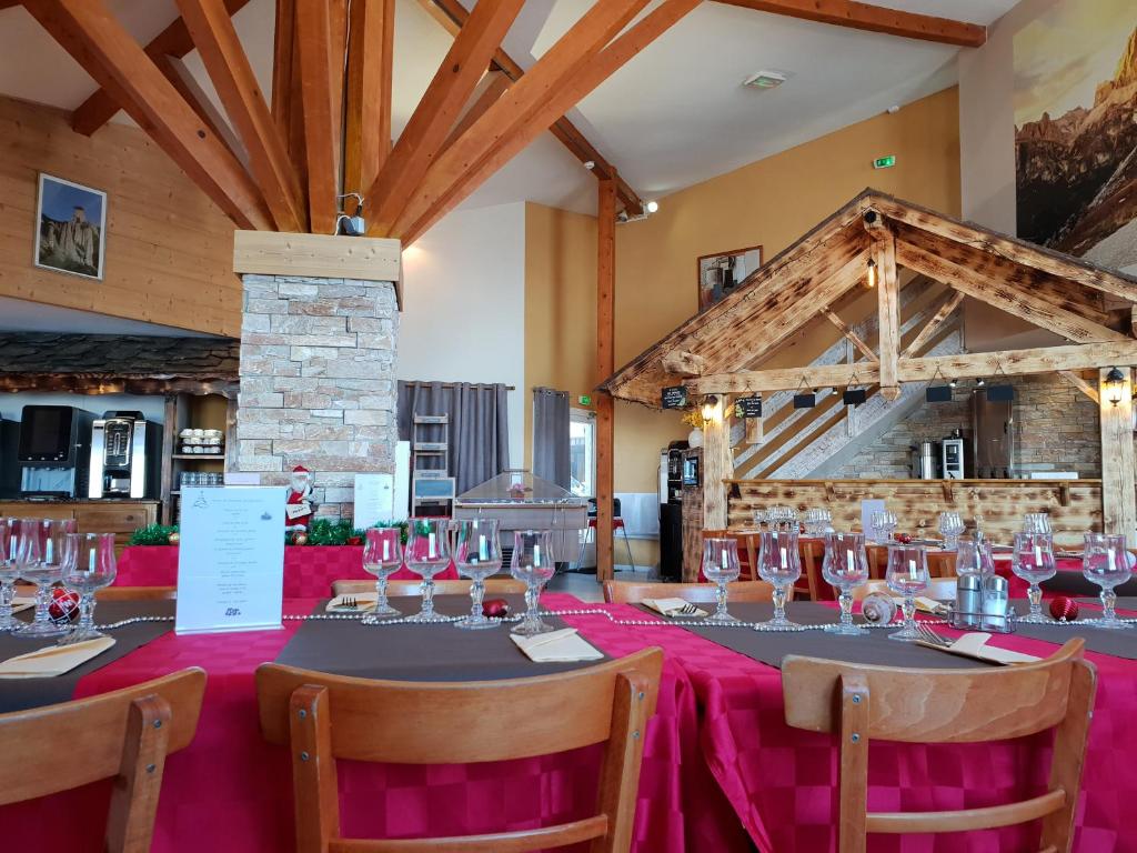 une salle à manger avec une table et des verres à vin dans l'établissement Hôtel Les Écrins, aux Orres