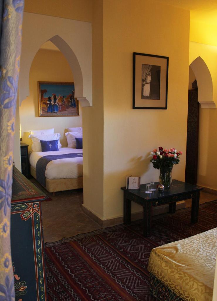 Cette chambre comprend 2 lits et une table fleurie. dans l'établissement Riad Léna & Spa, à Marrakech 37 autres photos