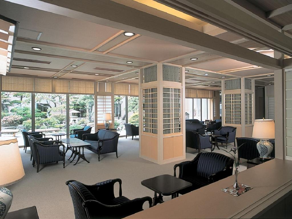 une salle d'attente avec des chaises, des tables et des fenêtres dans l'établissement Yunokawa Kanko Hotel Shoen, à Hakodate 57 autres photos