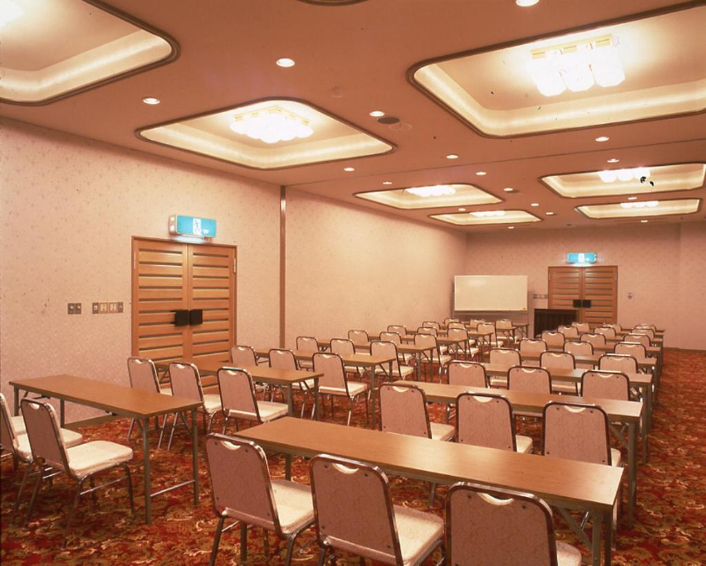 une salle de conférence avec des tables et des chaises ainsi qu'un podium dans l'établissement Hotel Seikoen, à Nikkō 13 autres photos