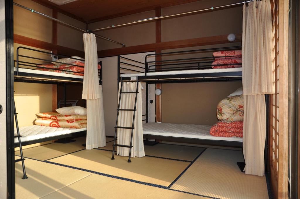 Cette chambre comprend 3 lits superposés avec des rideaux. dans l'établissement Riverside Hotel Karatsu Castle, à Karatsu
