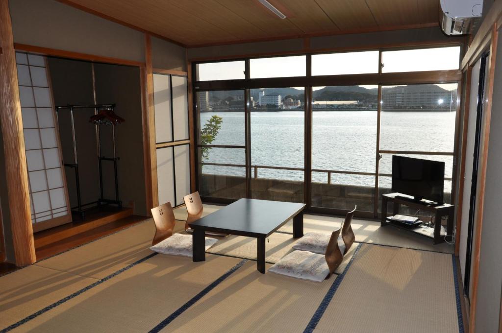 un salon avec une table, des chaises et une télévision dans l'établissement Riverside Hotel Karatsu Castle, à Karatsu