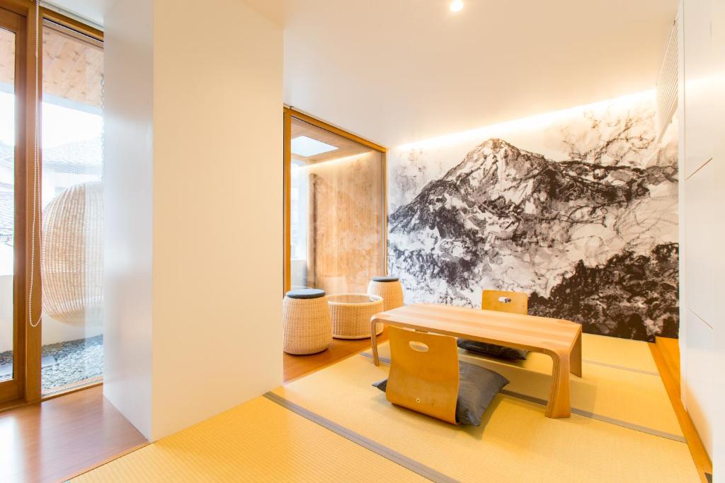 une chambre avec un banc et un tableau sur le mur dans l'établissement TSUCHIYA Kinosaki onsen, à Toyooka