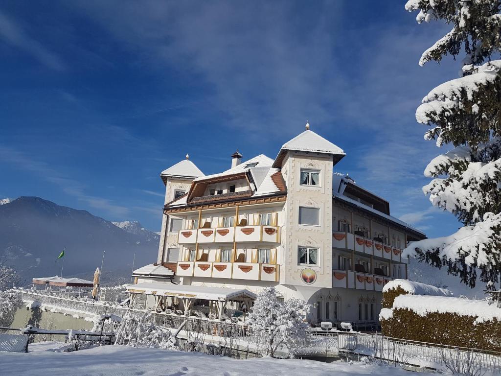 un grand bâtiment avec de la neige au sol dans l'établissement Alpenlandhotel Rodeneggerhof, à Rodengo