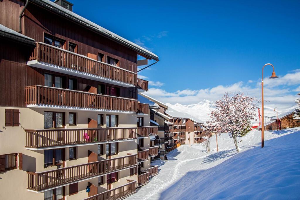 un bâtiment dans la neige avec une montagne en arrière-plan dans l'établissement 30 Praz Ski-in Ski-out Vallandry - Les Arcs - Paradiski, à Peisey-Nancroix