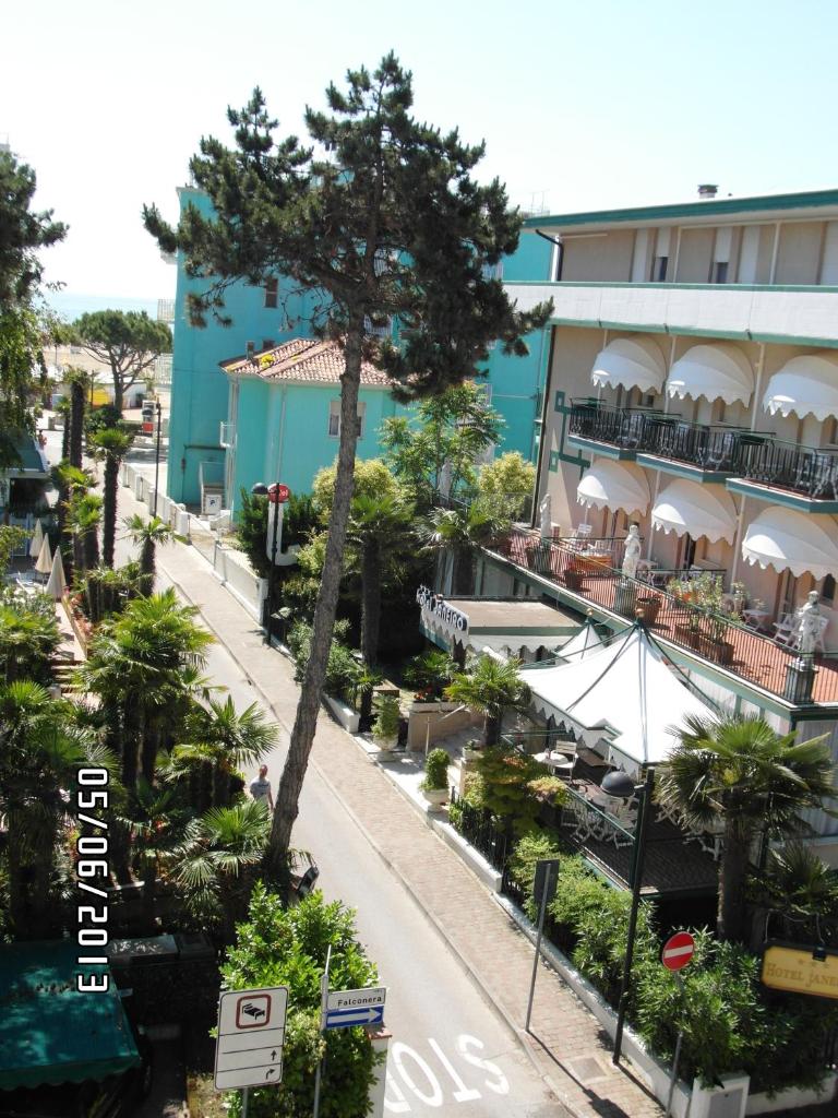 une rue en face d'un bâtiment avec un arbre dans l'établissement Hotel Villa Roma, à Caorle