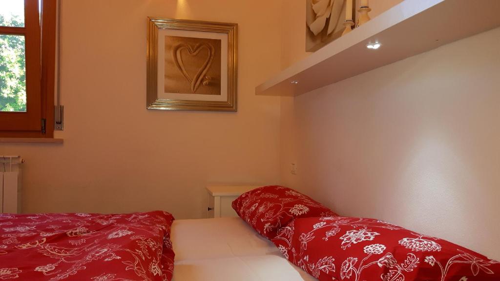 Cette petite chambre dispose d'oreillers rouges sur un lit. dans l'établissement Villa I Tamarigi, à Maruggio 36 autres photos