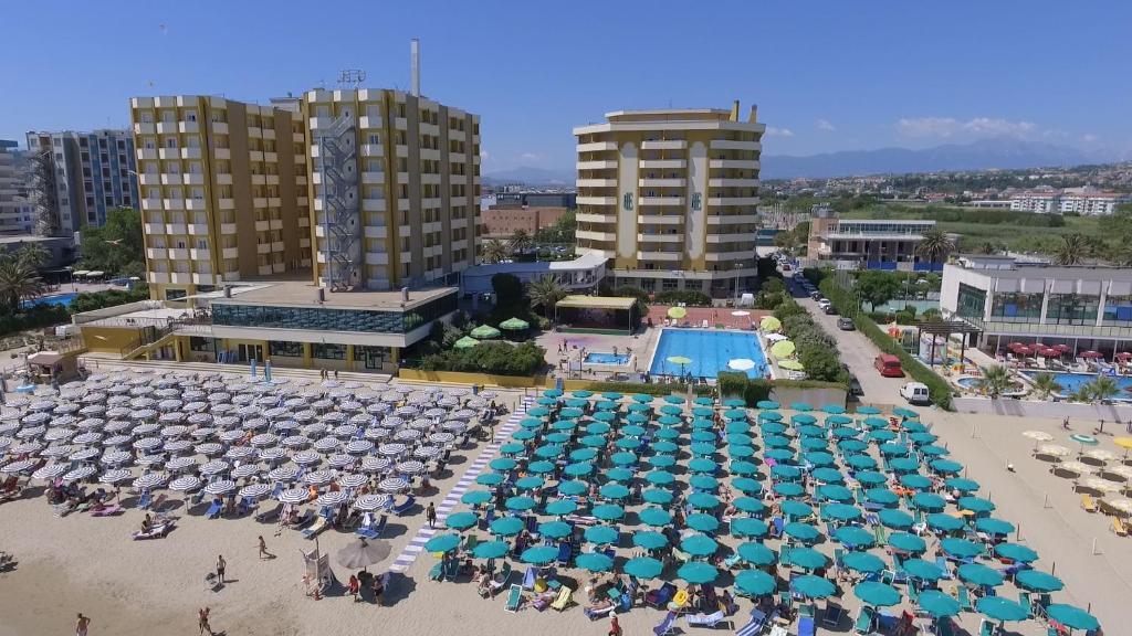 une vue aérienne d'une plage avec des parasols et une piscine dans l'établissement Grand Hotel Montesilvano, à Montesilvano