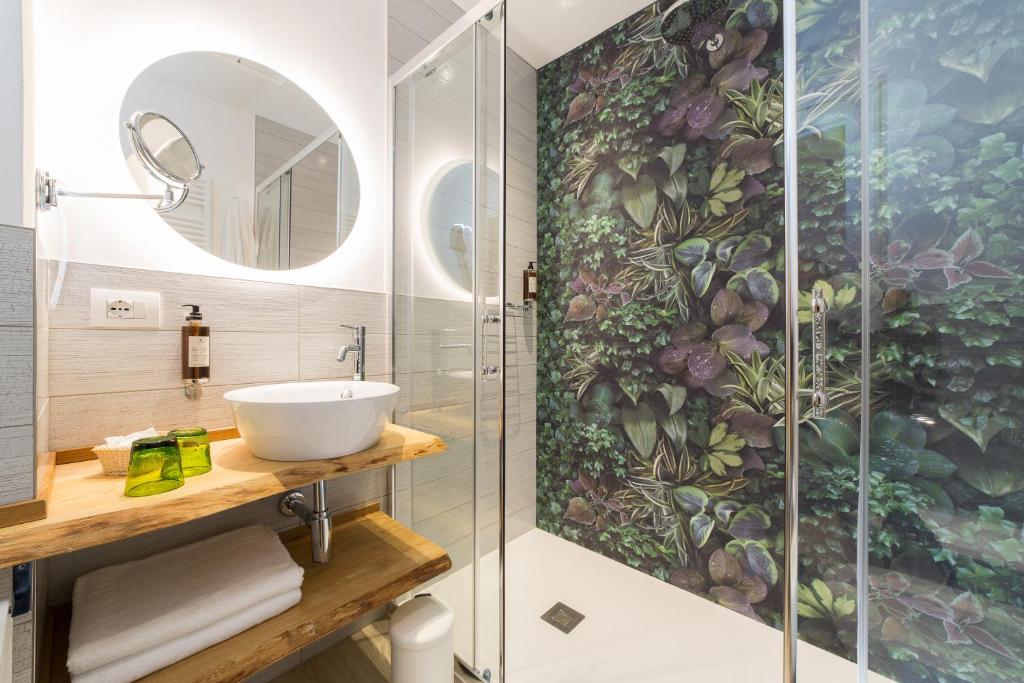 une salle de bain avec une douche avec un lavabo et un miroir dans l'établissement Hotel Solemare, à Milano Marittima