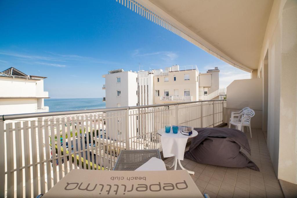un balcon avec une table et des chaises et l'océan dans l'établissement Hotel Solemare, à Milano Marittima