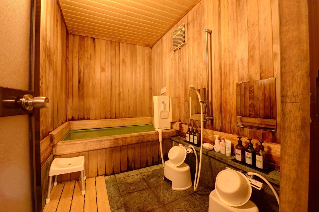 La salle de bains est pourvue d'une baignoire et de 2 toilettes. dans l'établissement Azuma Ryokan, à Kitakata