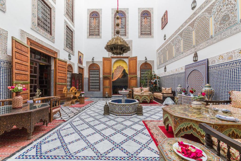 une pièce avec des tables et des chaises dans un bâtiment dans l'établissement Riad Ghita, à Fès