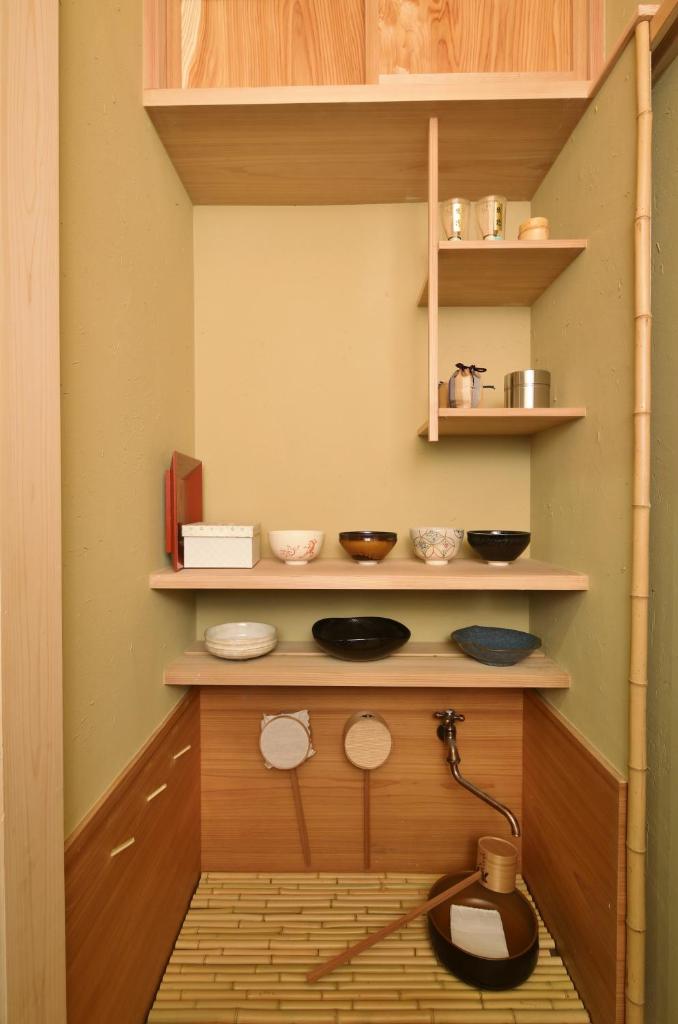 - une cuisine avec des étagères en bois et des bols dans l'établissement The Edo Sakura, à Tokyo