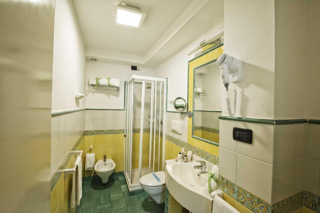 une salle de bain avec un lavabo et des toilettes dans l'établissement Grand Hotel Il Ninfeo, à Gaète