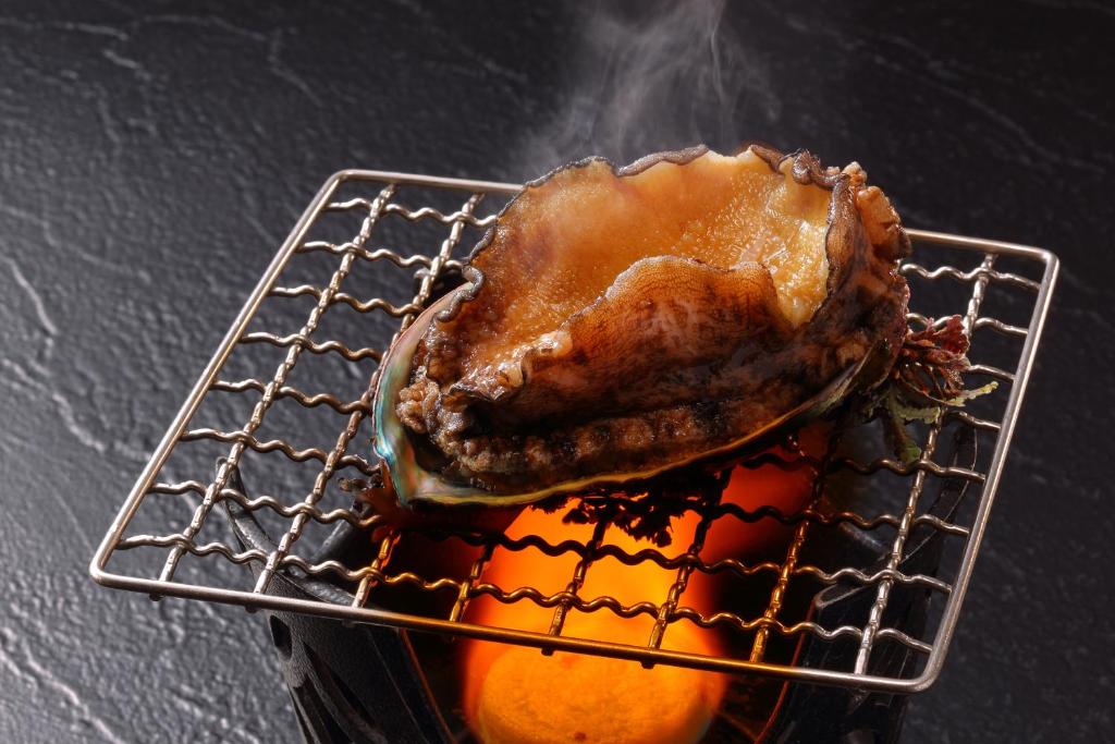 un morceau de viande sur un grill avec une orange dans l'établissement Hanashibuki, à Tateyama