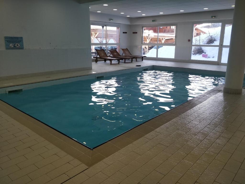 une piscine avec de l'eau bleue dans un immeuble dans l'établissement Appartement 4/6 personnes Puy Saint Vincent, à Puy-Saint-Vincent