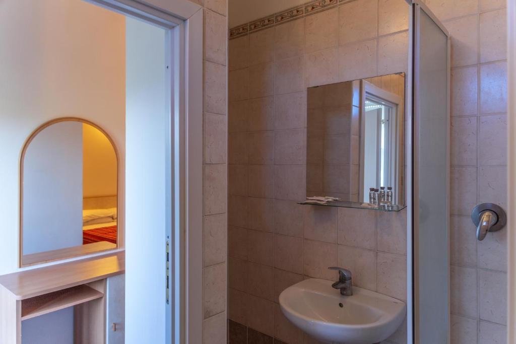 une salle de bain avec un lavabo et un miroir dans l'établissement Hotel Beverly, à Rimini