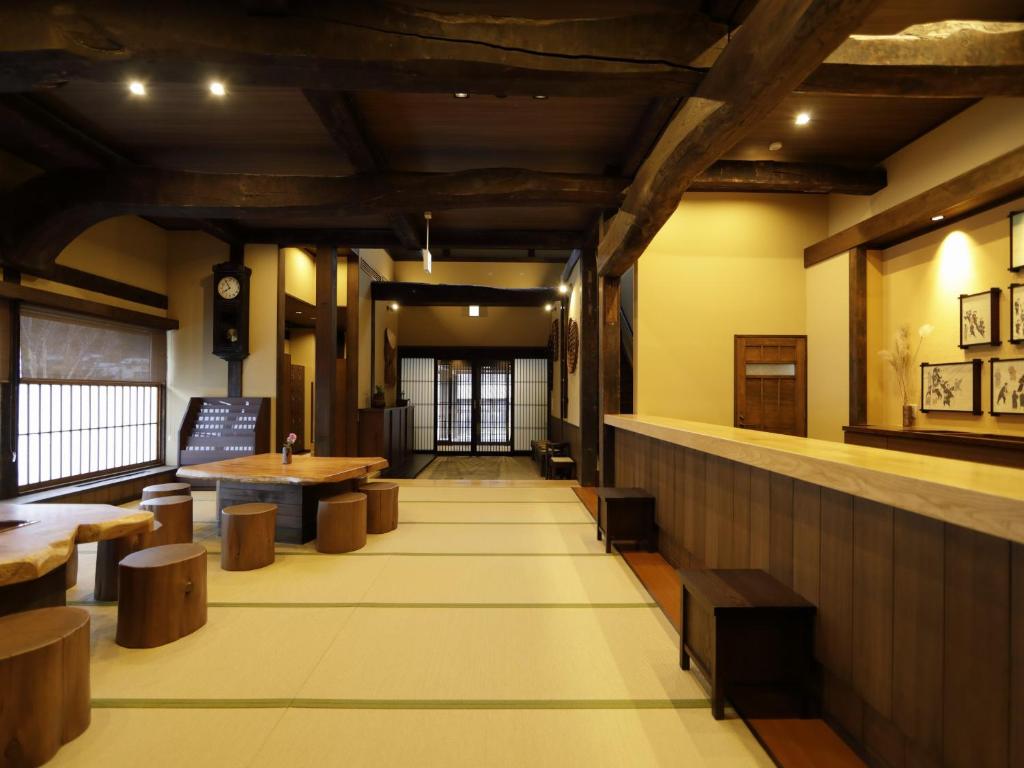 un restaurant avec des plafonds en bois, des tables et des bancs dans l'établissement Onyado Yuinosho, Shirakawago, à Shirakawa-gō