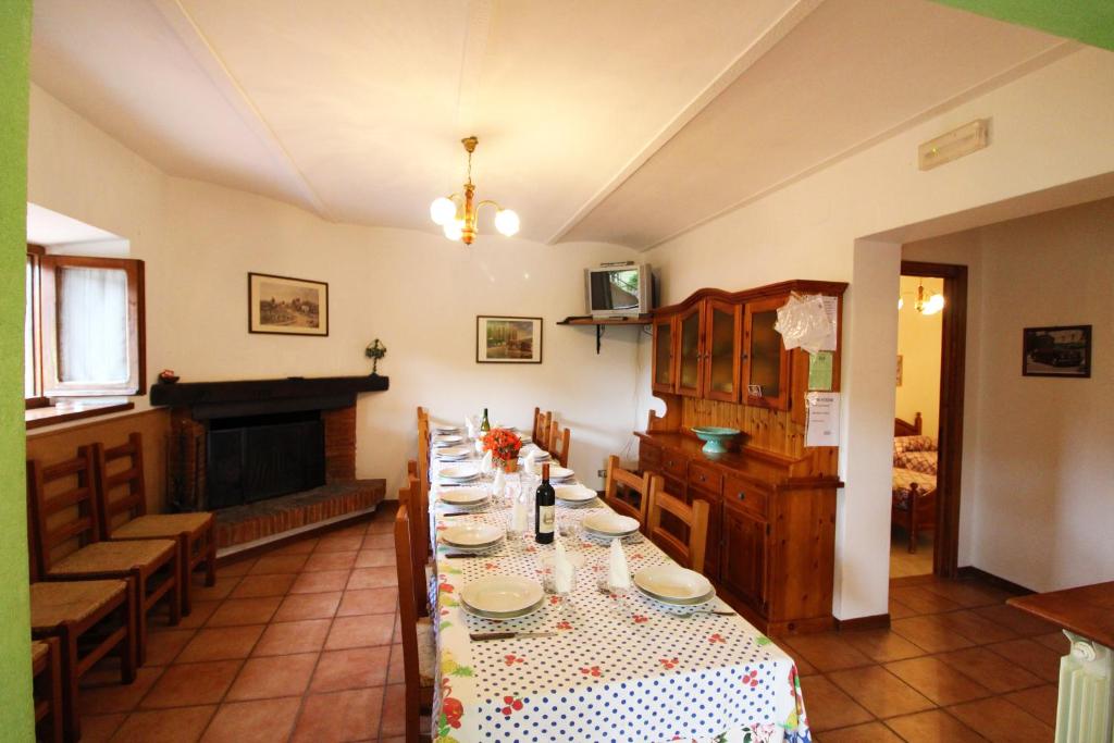 une salle à manger avec une grande table et une cheminée dans l'établissement Casale Aiola, à Poggioni