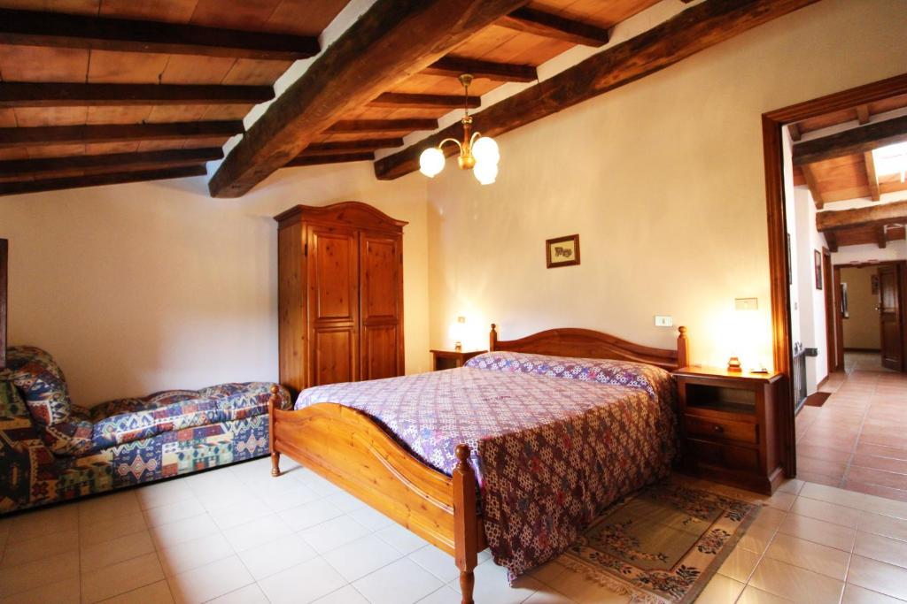 une chambre avec un lit et une chaise dedans dans l'établissement Casale Aiola, à Poggioni