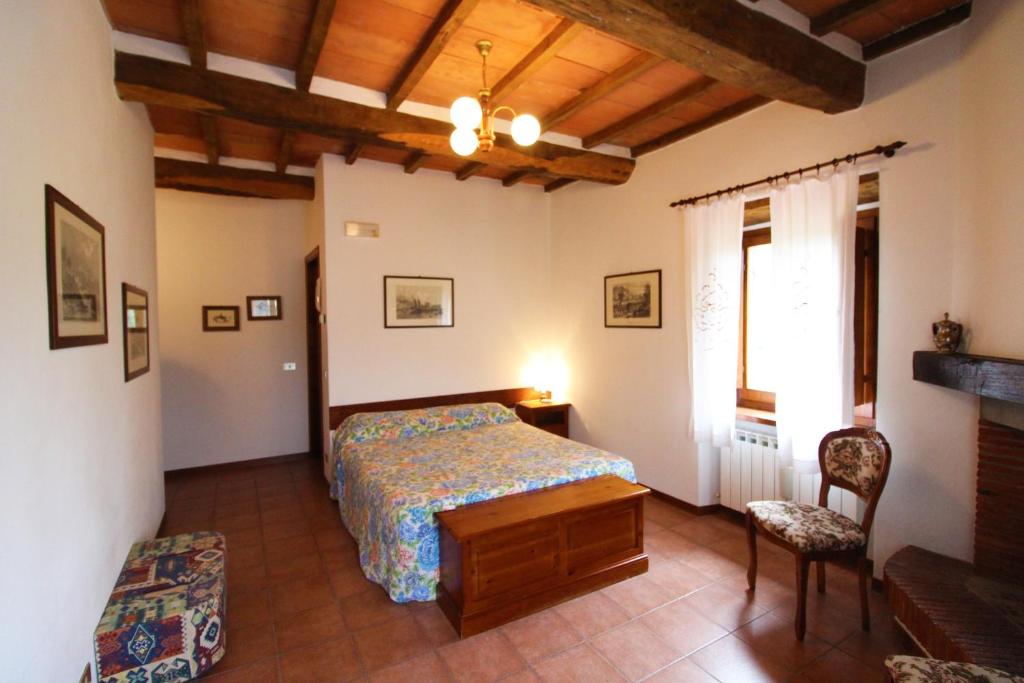 une chambre avec un lit, une chaise et une fenêtre dans l'établissement Casale Aiola, à Poggioni 30 autres photos
