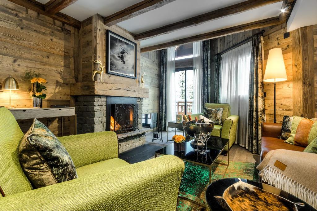 un salon avec un canapé et une cheminée dans l'établissement Hôtel La Sivolière, à Courchevel
