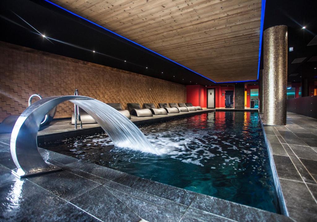 - une piscine avec une fontaine dans un bâtiment dans l'établissement Hôtel Daria-I Nor by Les Etincelles, à L'Alpe-d'Huez