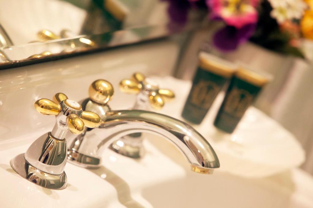 La salle de bains est pourvue d'un lavabo et d'un robinet doré. dans l'établissement Baia D'Argento, à Porto Santo Stefano