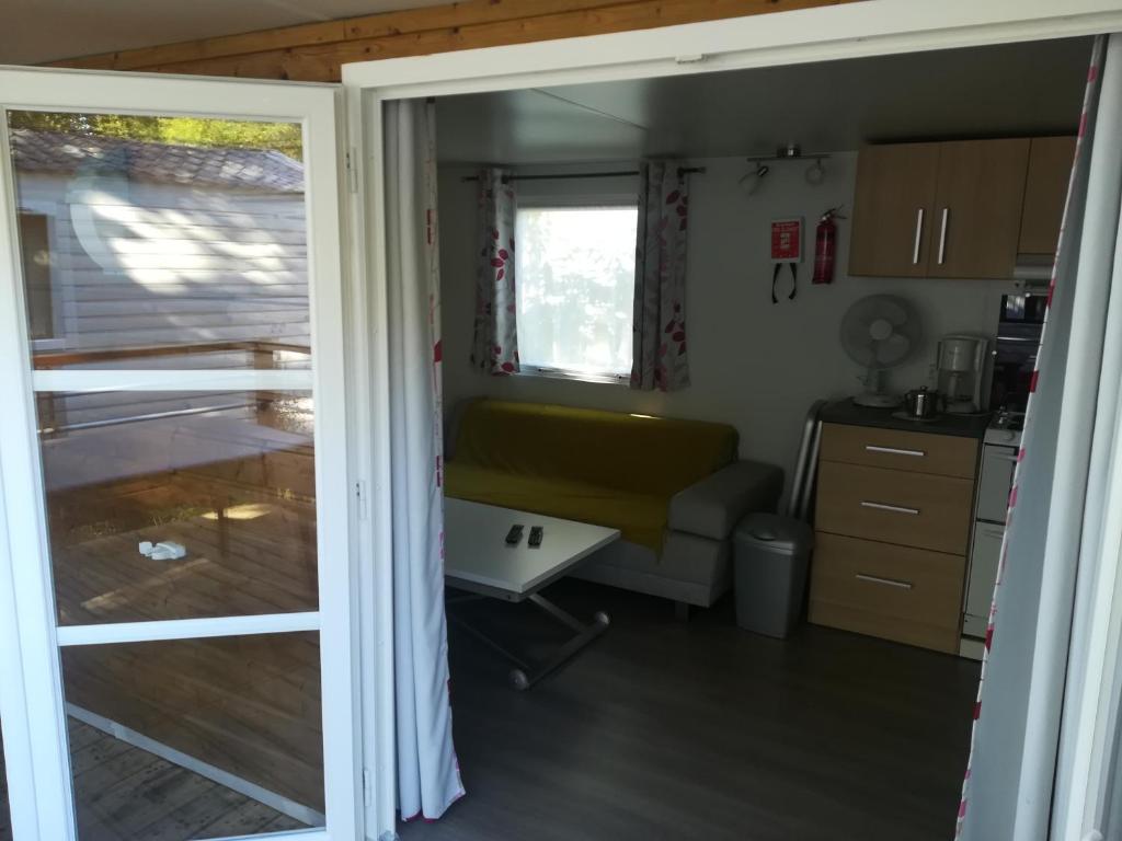 Cette caravane comprend une cuisine et une porte coulissante en verre. dans l'établissement MH Camping 4* face Royan, à Soulac-sur-Mer 5 autres photos