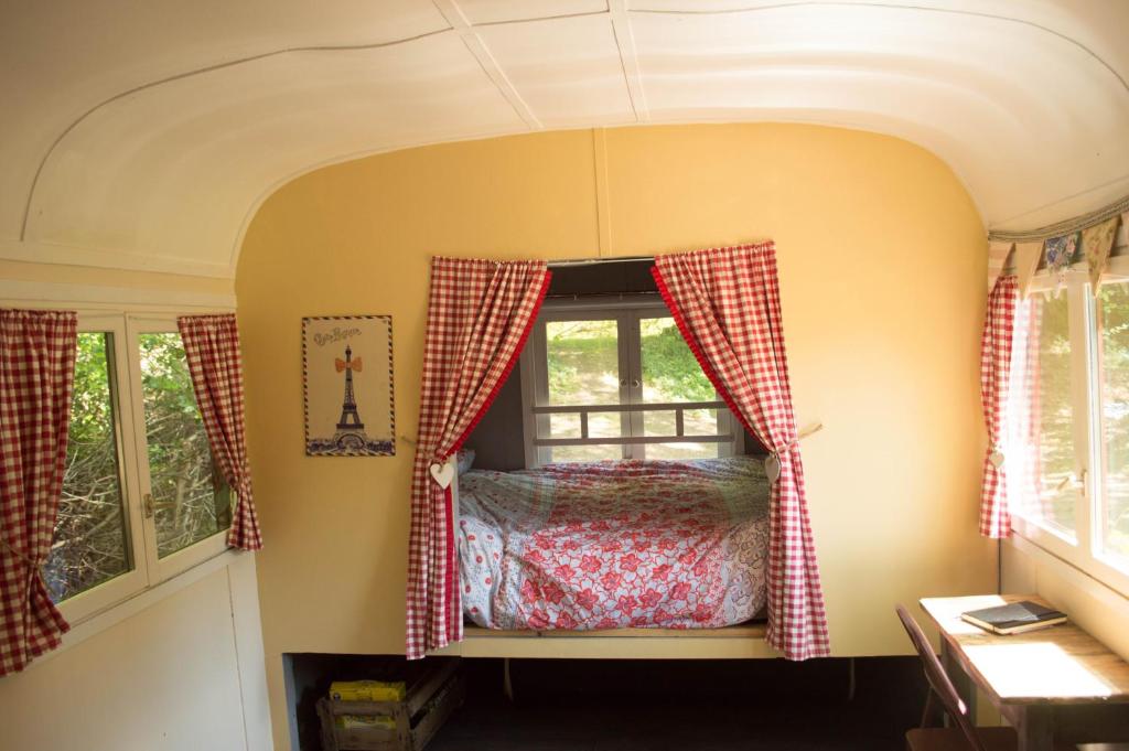 - une chambre dans un wagon avec un lit dans une fenêtre dans l'établissement GoGreen Roulotte, à Saint-Priest-les-Fougères 20 autres photos