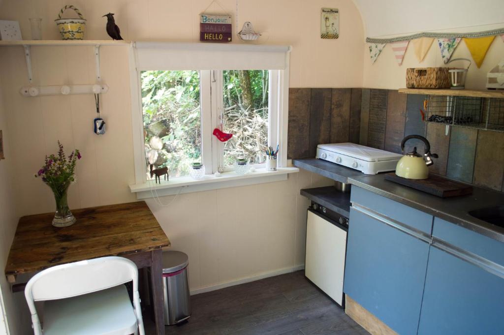 une petite cuisine avec un comptoir et une fenêtre dans l'établissement GoGreen Roulotte, à Saint-Priest-les-Fougères