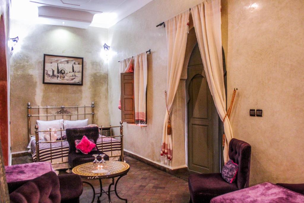 un salon avec un lit, une table et des chaises dans l'établissement Riad Minorisa, à Marrakech